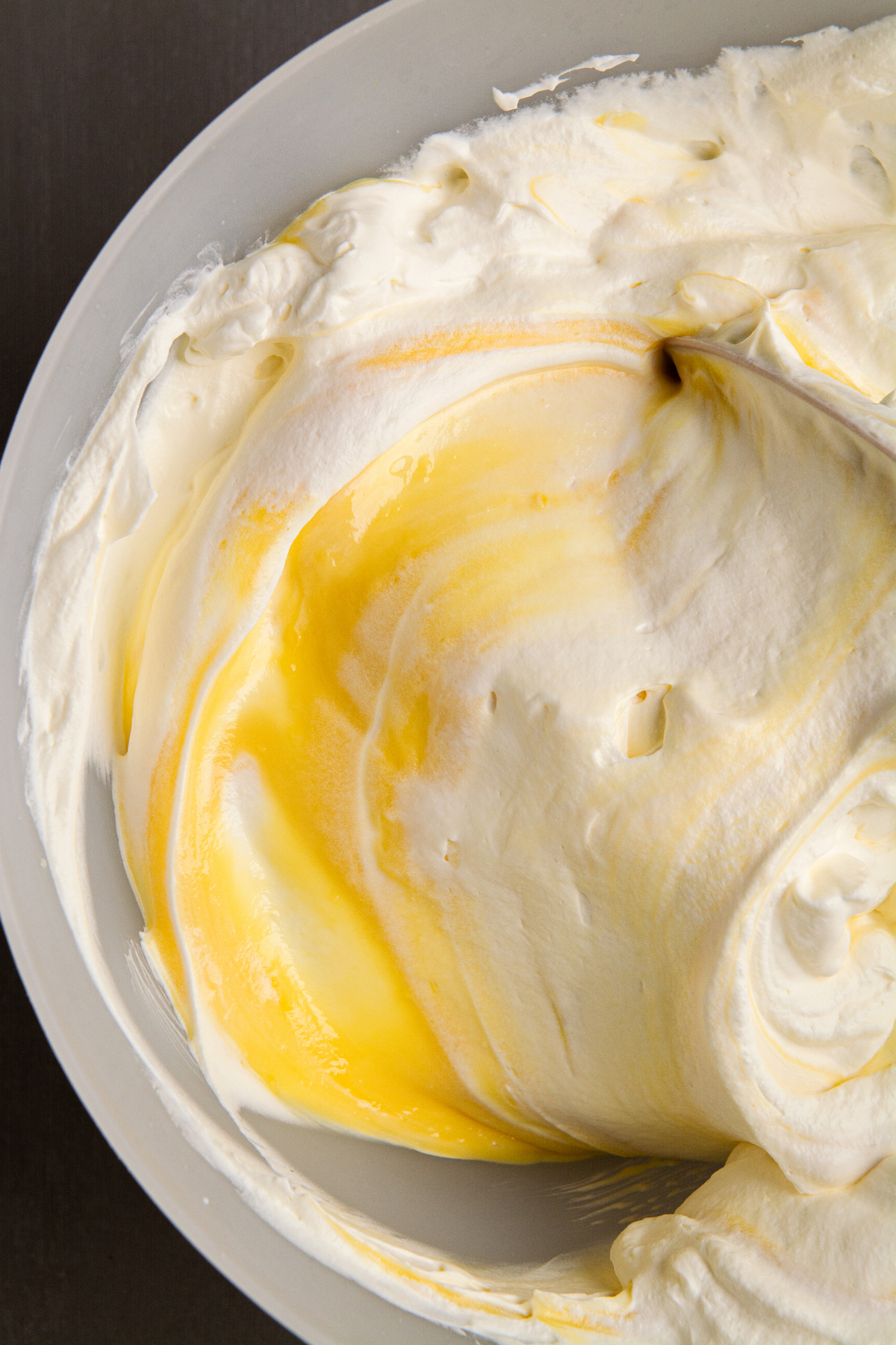 A bowl of fluffy whipped cream folded into set vanilla pudding.