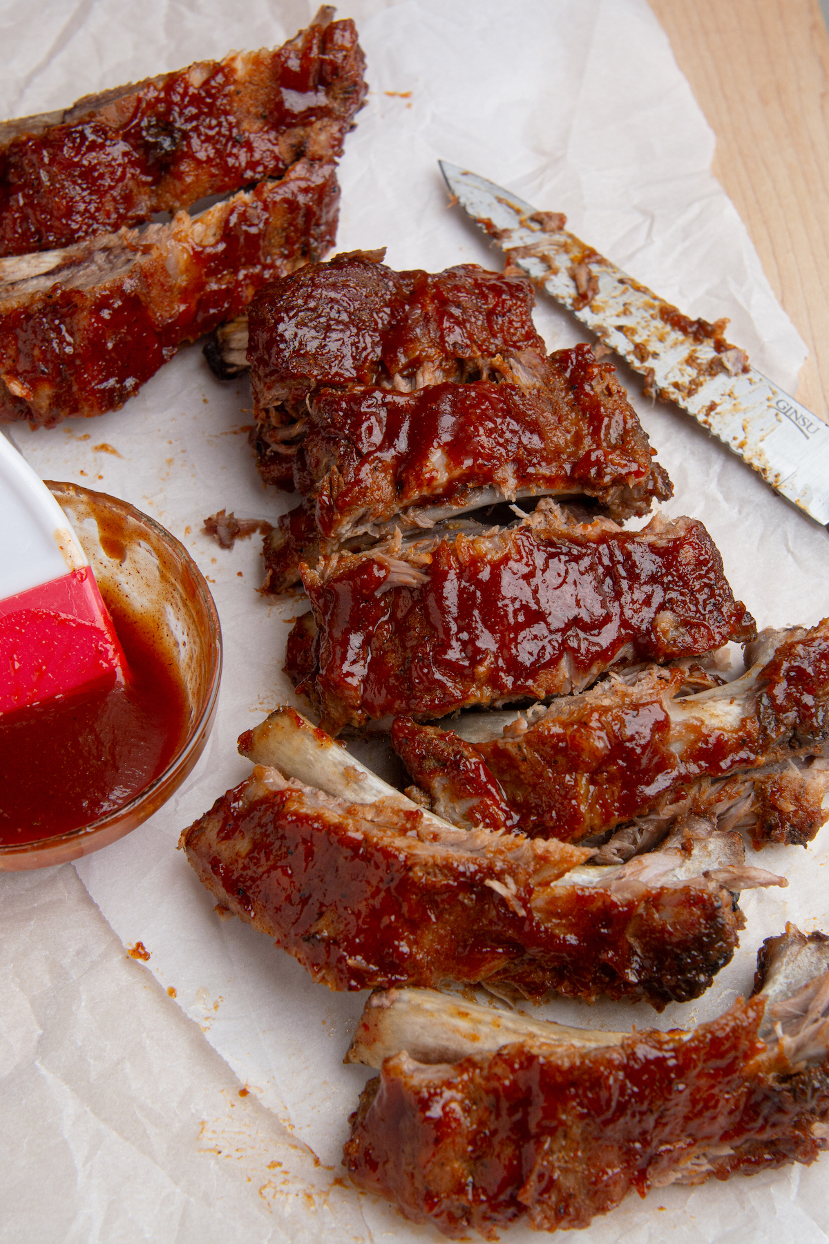 Instant pot baby back ribs smothered in BBQ sauce cut into individual ribs.