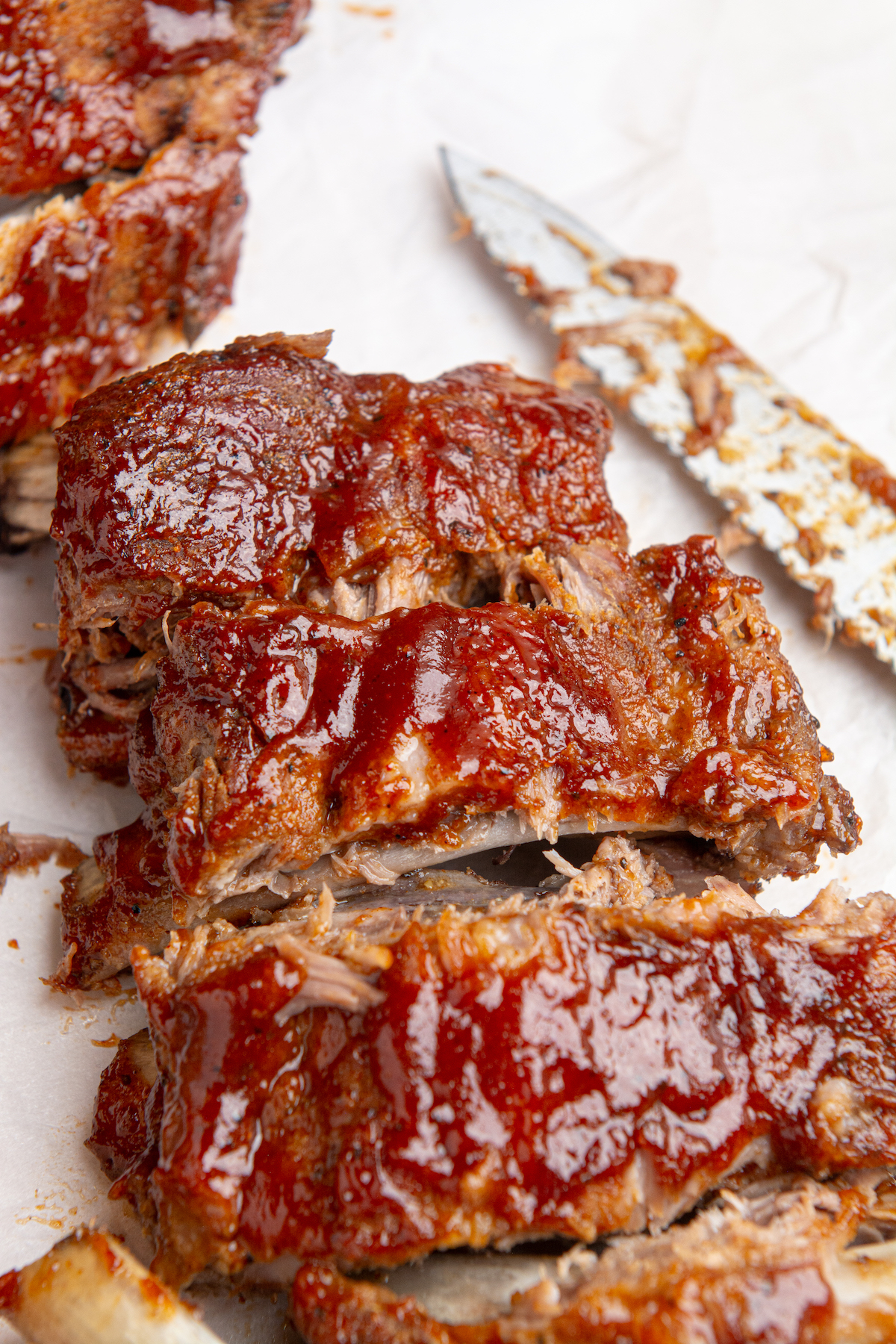 Instant pot baby back ribs smothered in BBQ sauce cut into individual ribs.