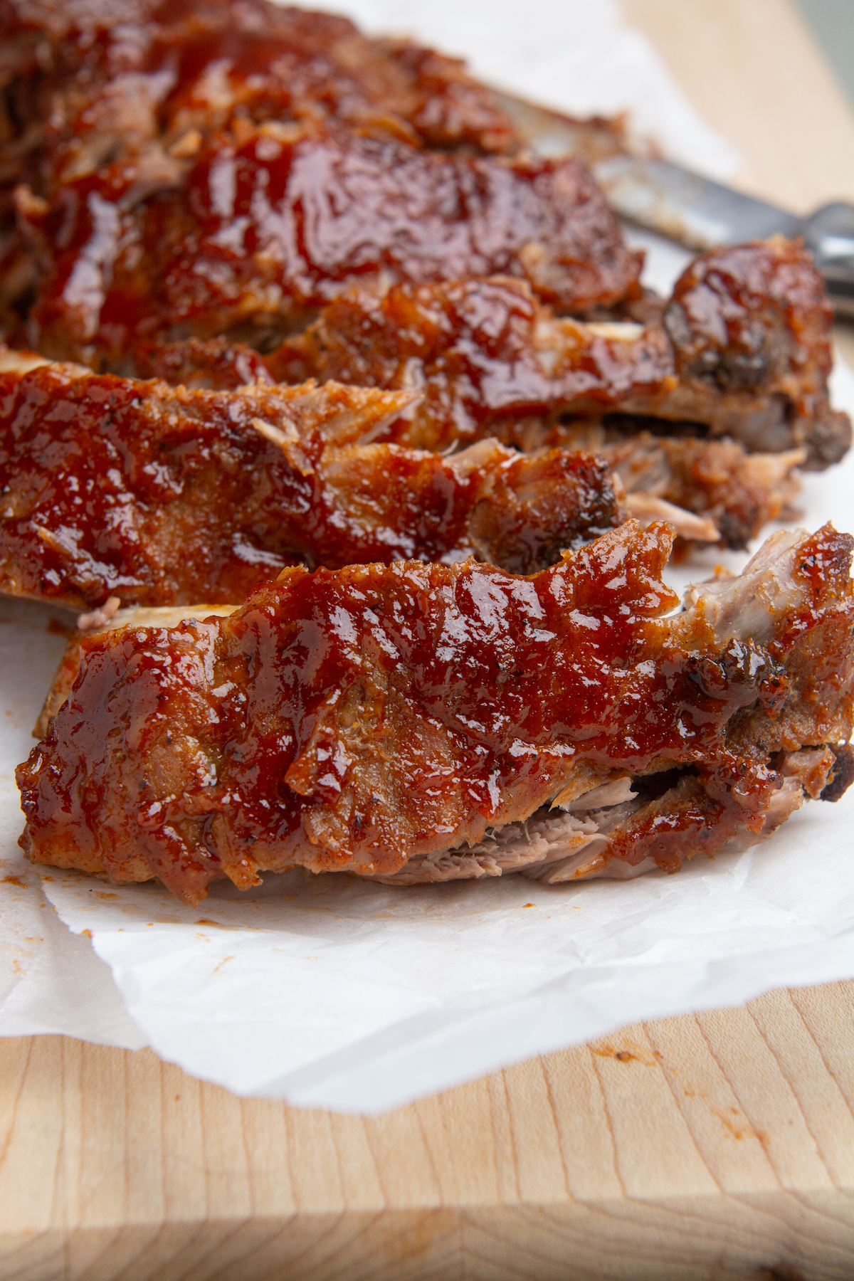 Instant pot baby back ribs smothered in BBQ sauce cut into individual ribs.