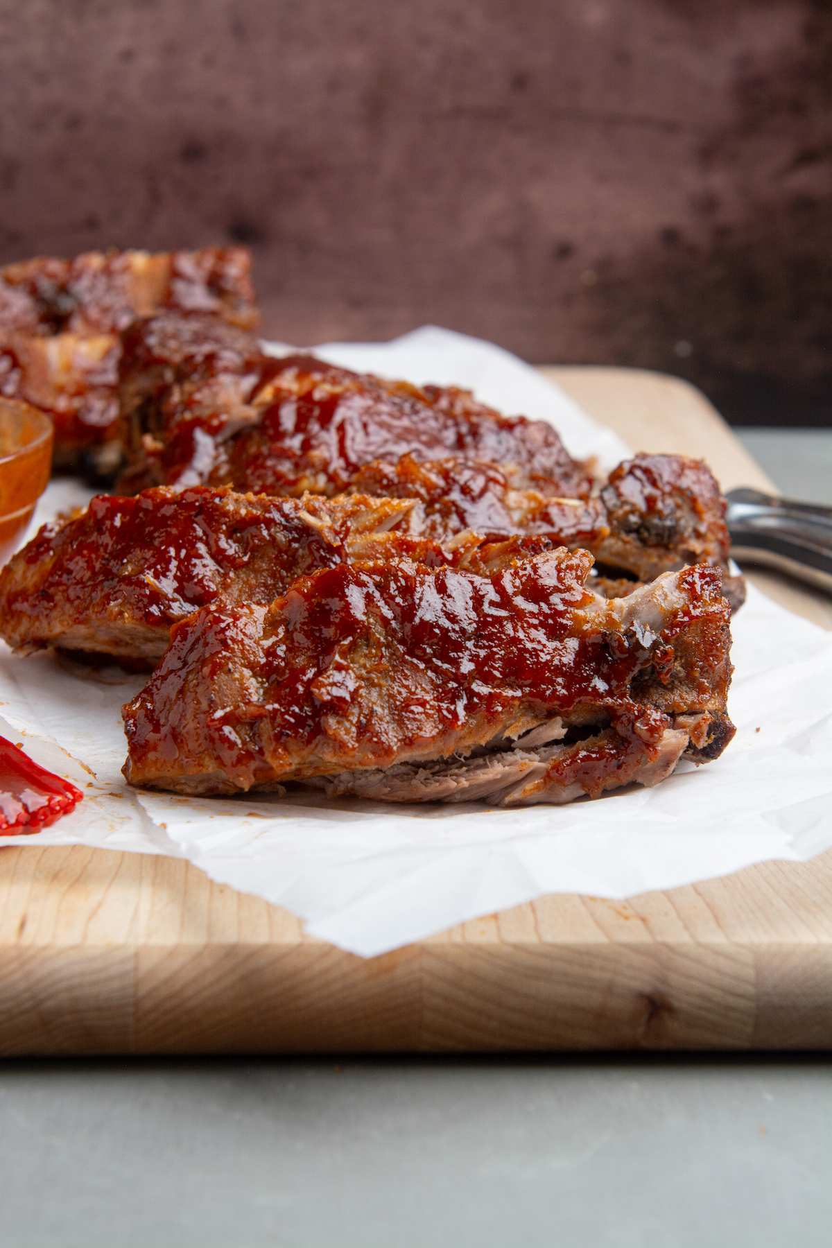 Instant pot baby back ribs smothered in BBQ sauce cut into individual ribs.