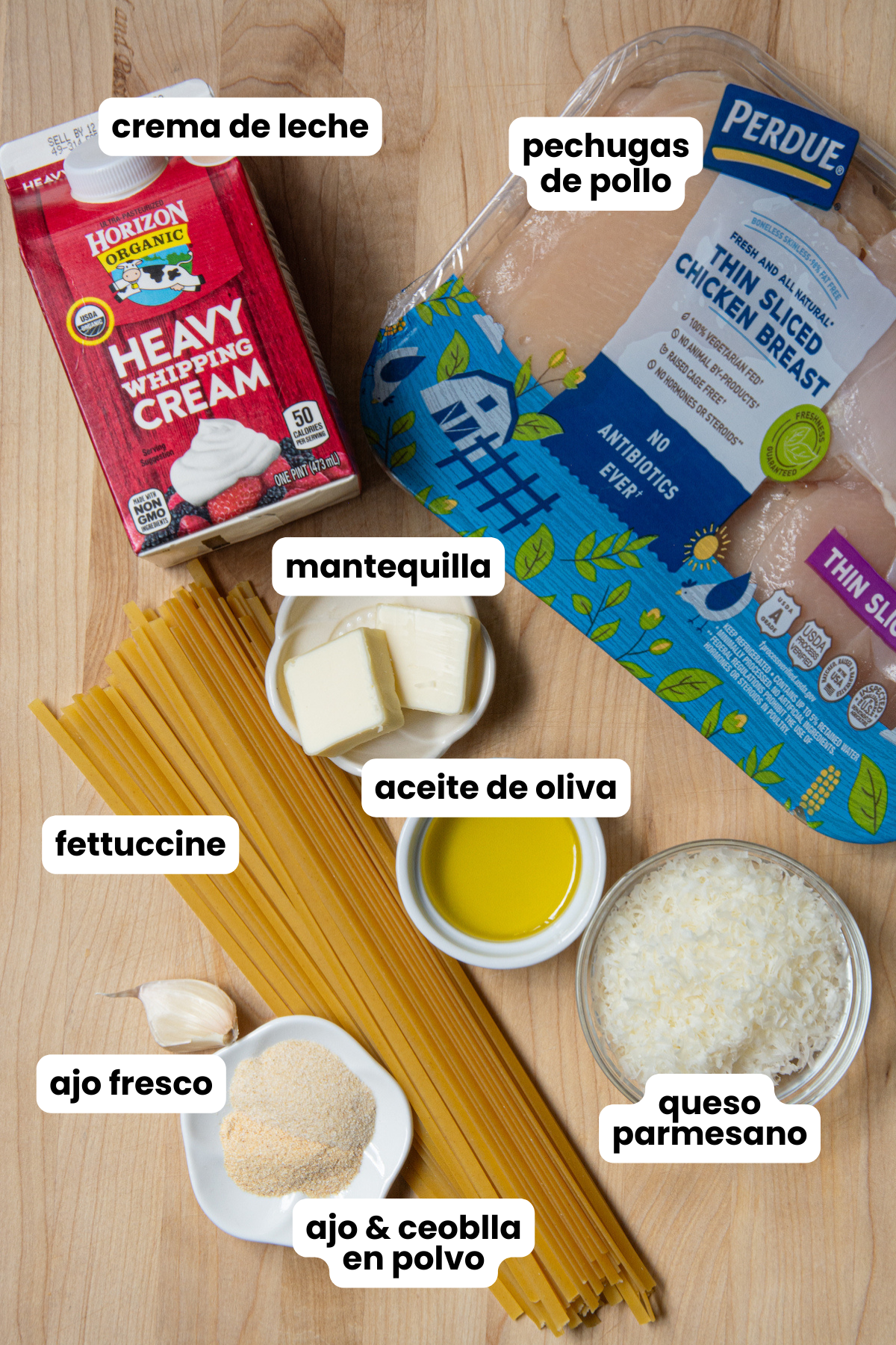 Ingredients for a chicken Alfredo with fettuccine, which include fettuccine pasta, chicken breasts, garlic powder, onion powder, fresh garlic, butter, olive oil, heavy cream and grated Parmesan cheese.