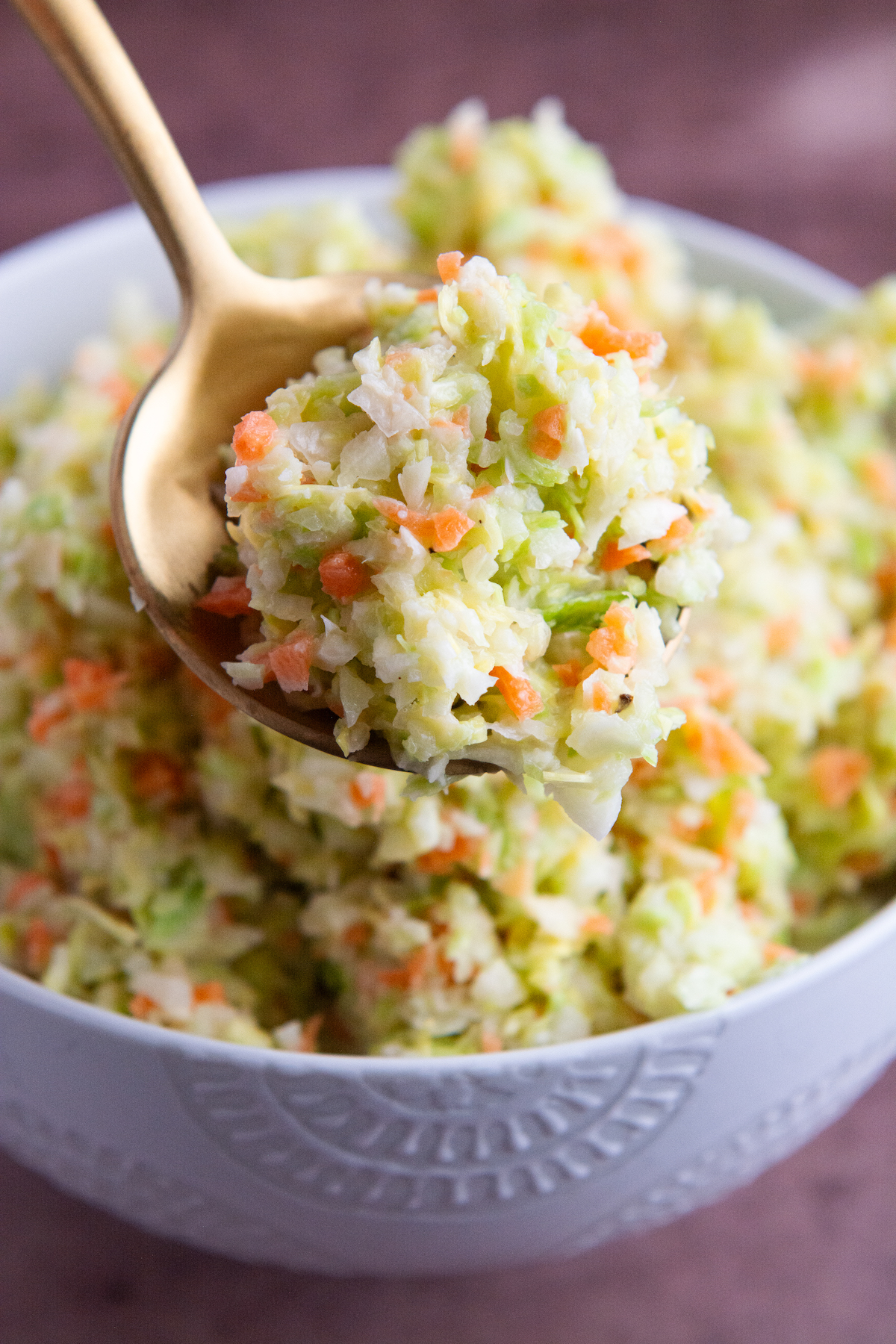 A spoonful of a copycat KFC coleslaw made with chopped green cabbage and carrot, tossed in a sweet and tangy buttermilk dressing.