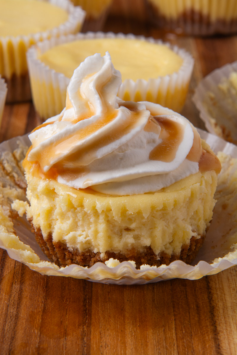 A mini cheesecake topped with whipped cream and drizzled with salted caramel